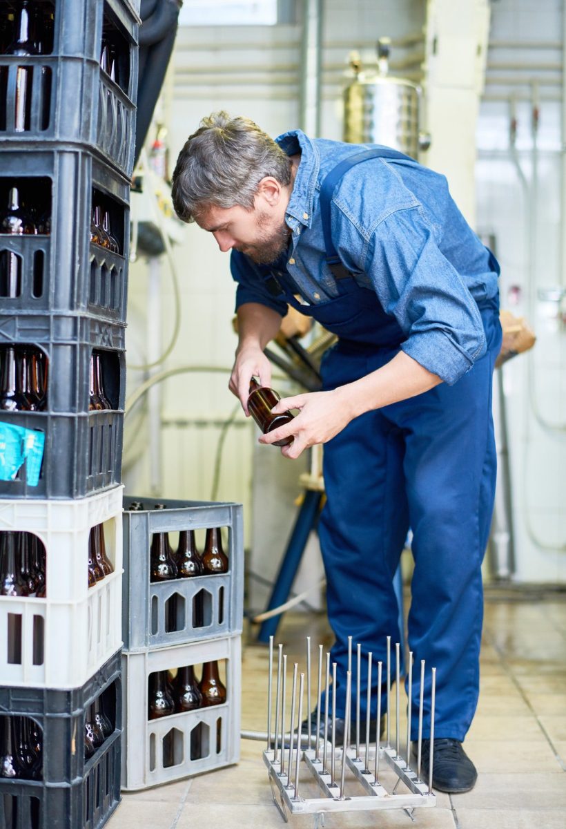 modern brewery worker preparing beer bottles for loading.jpg